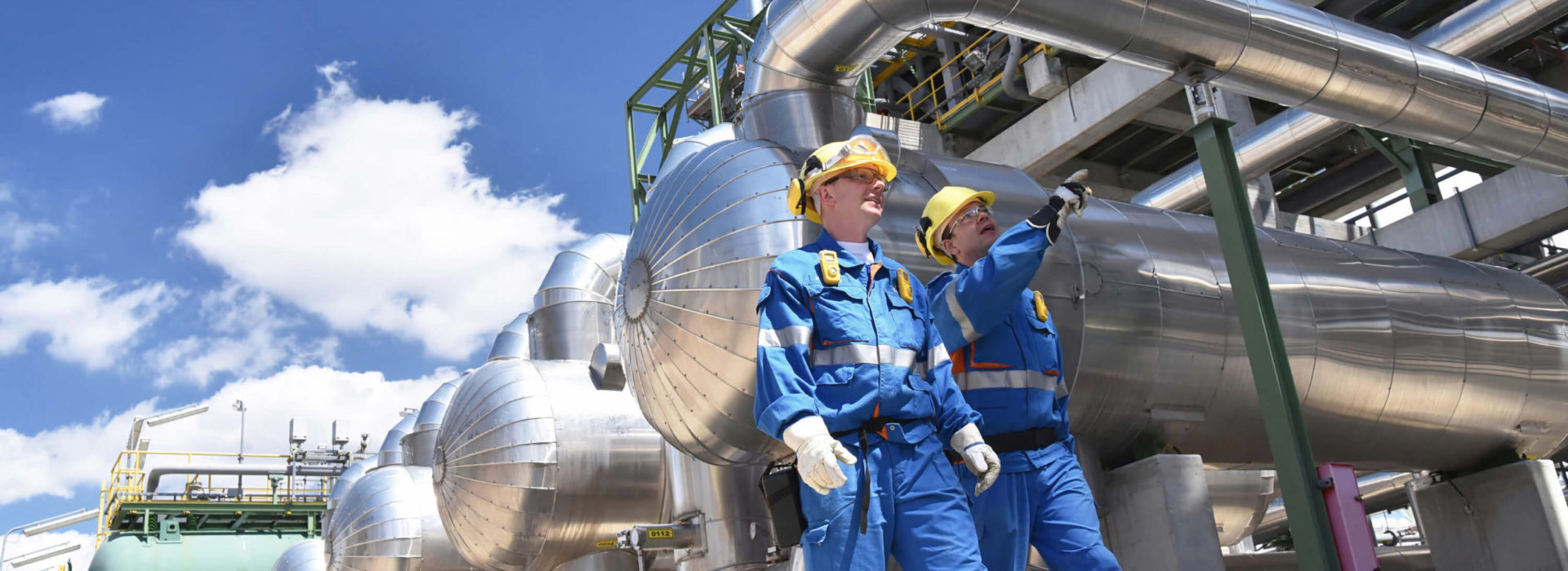 Two workers walk to the Motor Oil refinery